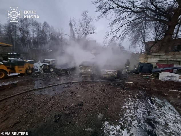A firefighter works at the site of a car repair workshop damaged during Russian missile and drone strikes, amid Russia's attack on Ukraine, in Kyiv, Ukraine December 27, 2025