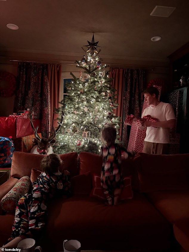 The star shared a sweet snap of his family opening presents by the tree