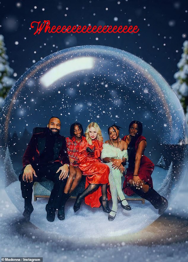 In one festive snow-globe-style snap, the star appeared in high spirits as she posed alongside her family