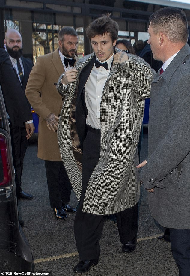 Cruz Beckham sports a grey long coat as he makes his way to Holly Ramsay and Adam Peaty's wedding ceremony