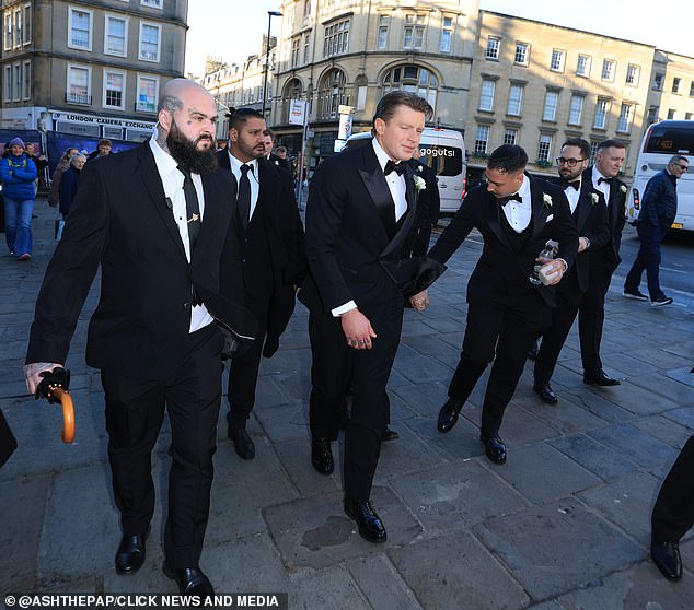 Peaty wearing a smart black suit with a bow tie, arriving at Bath Abbey ahead of his wedding to Holly Ramsay today