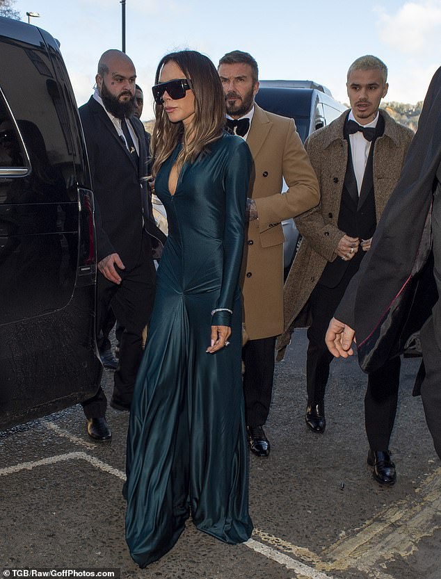 The chic outfit featured a plunging neckline, long sleeves, pleated waist detailing, and a front skirt split