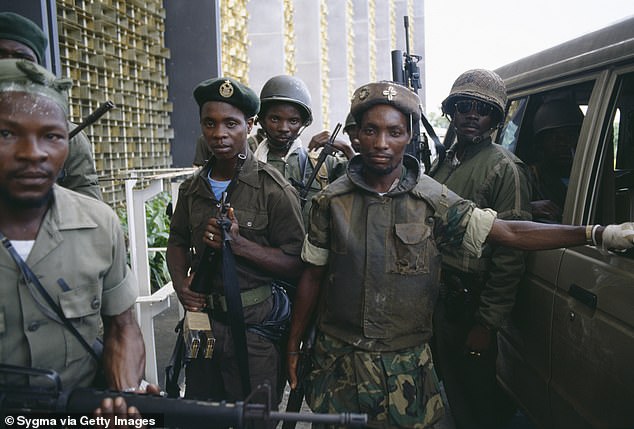 Colonel Michael Tilly, right, seen with his fighters. He was the leader of the Death Squad, a faction of president Doe's armed forces and oversaw the killing of the 600 people at the St Peter's Lutheran Church
