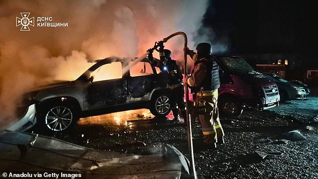 Firefighter crews work to extinguish flames following a Russian attack on Kyiv