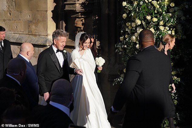 She kept her lace gown concealed beneath a billowing hooded ivory cloak