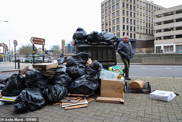 A man walks past a pile of rubbish on Horse Fair in Birmingham City Centre