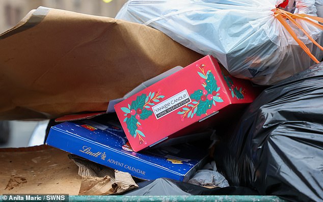 Festive present packaging, including a Yankee Candle box, is dumped among the rubbish piles