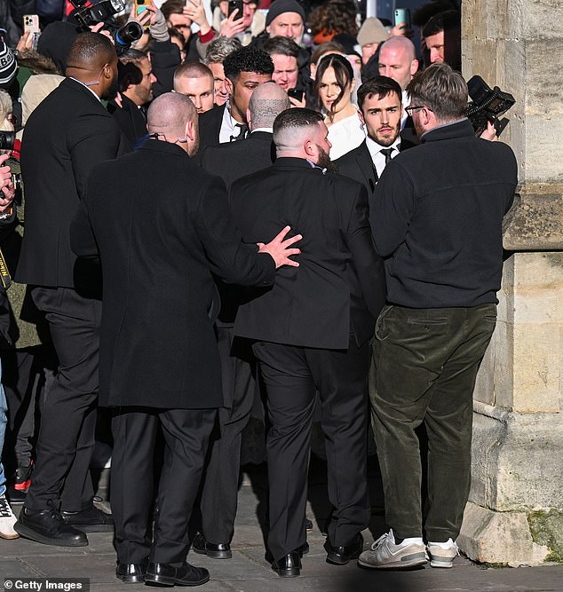 Security formed a protective ring around the bride and her famous family as they struggled through the confined passageway besides historic the venue.