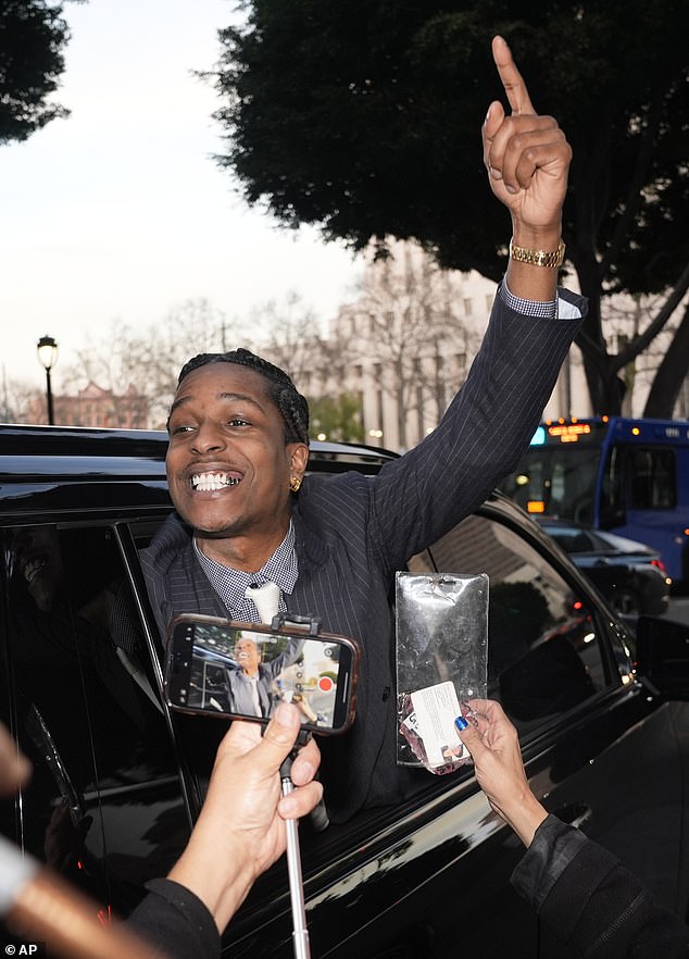 A beaming A$AP Rocky leaves court after fighting through the mob of fans outside the court