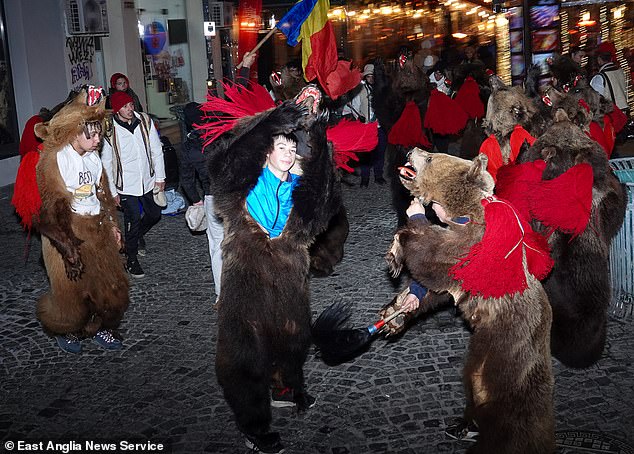 Now, with wages increasing by 700 per cent in the last ten years, cheaper housing, low unemployment and a perceived lower crime rate, Romania is seen as a better place to settle. Pictured: Revellers dancing in traditional bear costumes in Bucharest