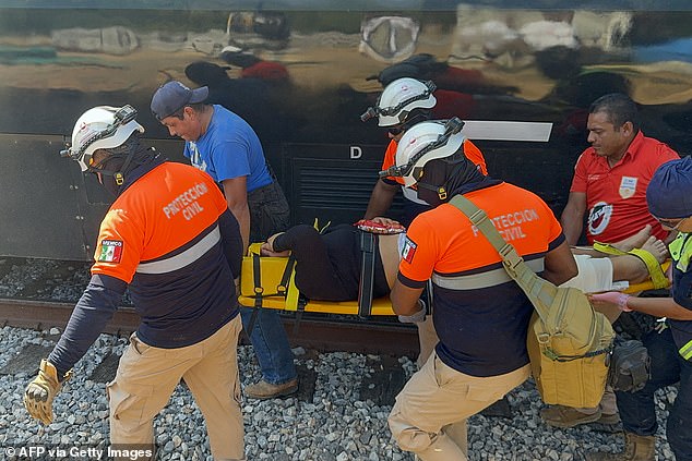 A passenger is carried away from the train on a stretcher by members of the Civil Protection
