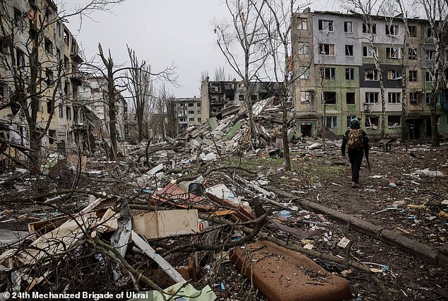 A Ukrainian military member walking in a heavily damaged residential area of the frontline town of Kostyantynivka, in the Donetsk region