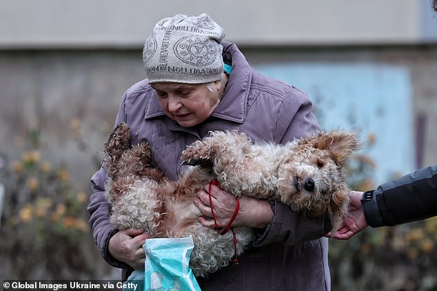 Zelensky said his only priority is ending the war. A woman is pictured carrying a dog in her arms in Kyiv on December 23