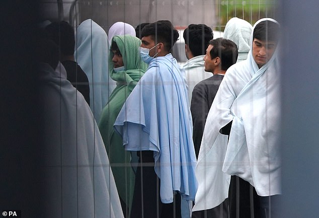 A view of people thought to be migrants inside the Manston immigration short-term holding facility located at the former Defence Fire Training and Development Centre in Thanet, Kent
