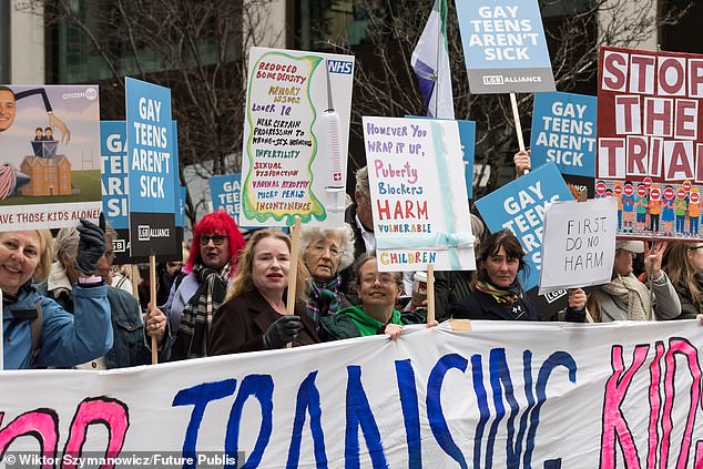 Demonstrators gather outside the Department of Health and Social Care to protest against the planned clinical trial to assess puberty blockers in gender questioning children in London