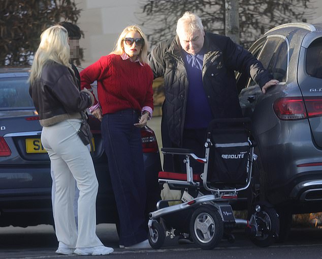 Katie looked suitably festive in a red jumper, red and white striped shirt and blue jeans