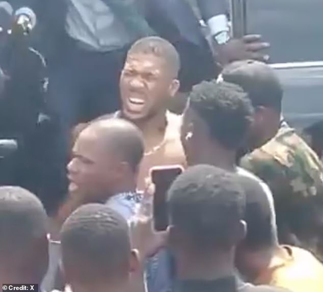 Joshua pictured after the car crash in Nigeria on Monday which killed two people. The star came within inches of death in the crash