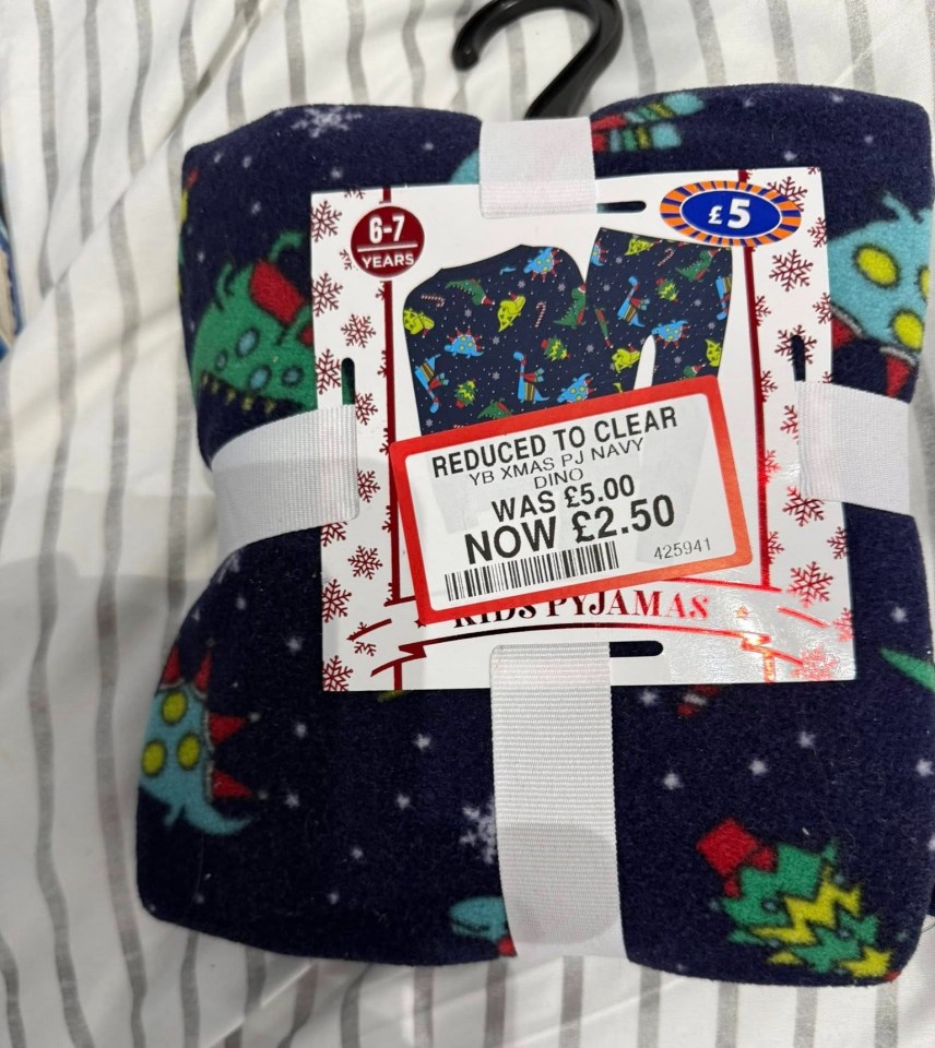 Folded Christmas pajamas for 6-7 year olds, featuring a dinosaur design, marked down from £5.00 to £2.50.