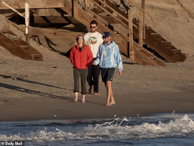 The actor cracked a smile as he trekked across the beach barefoot in what appeared to be a moment of positivity amidst his family's painful ordeal