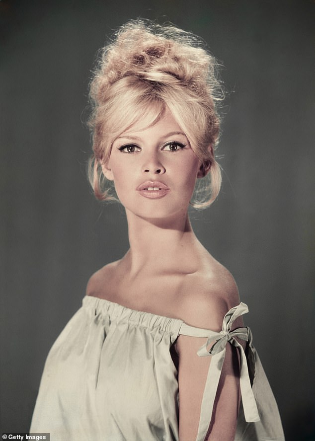Studio portrait of actor and model Brigitte Bardot wearing a light blue off-the-shoulder dress in 1960
