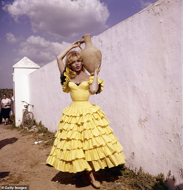 Portrait of French actress Brigitte Bardot in Spanish dress holding a jug, circa 1960s