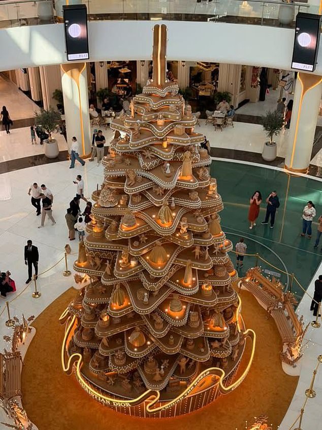 A Christian Dior Christmas tree is pictured at the Dubai Mall as onlookers look up at the towering structure in awe