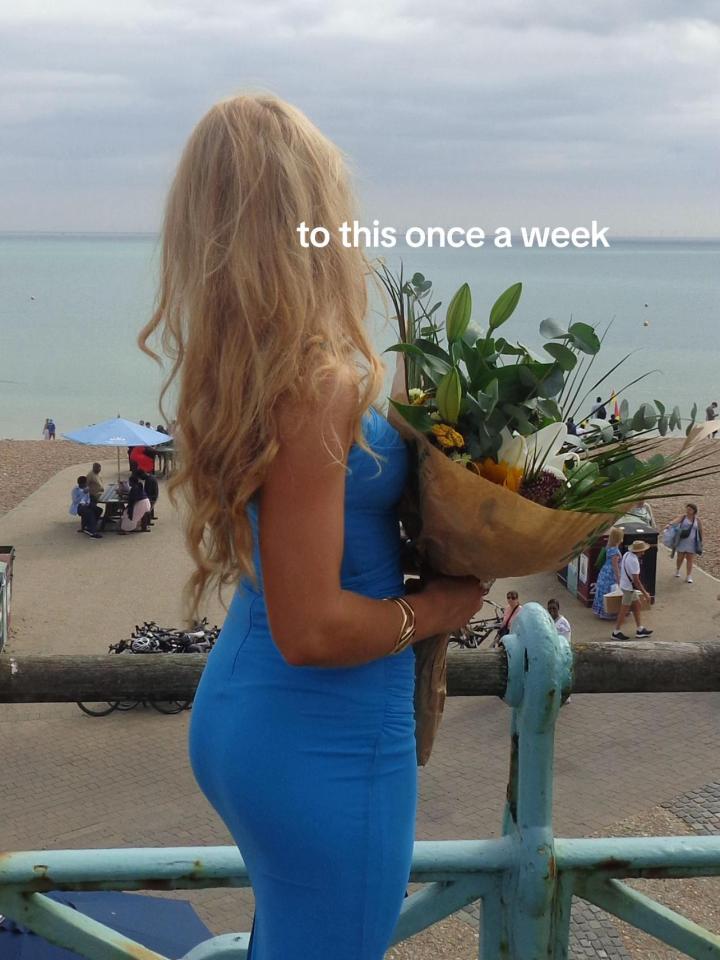 Blonde woman in a blue dress holding a bouquet of flowers overlooking the sea.