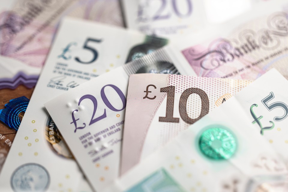 British Pound Sterling Banknotes and Coins. Close up of Bank of England notes.