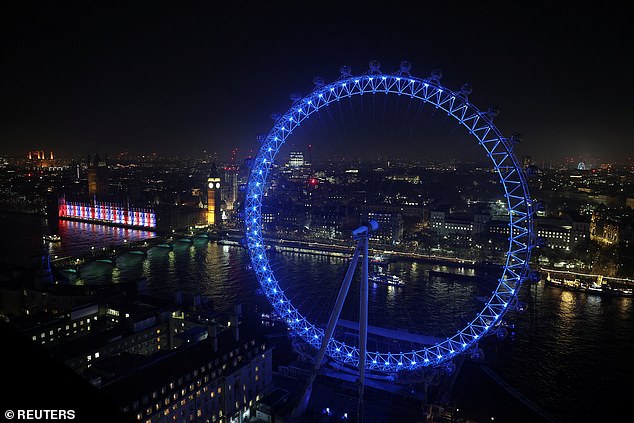 Crowds gather in official areas along the banks of the River Thames and on Westminster Bridge as the London Eye emits a blue glow