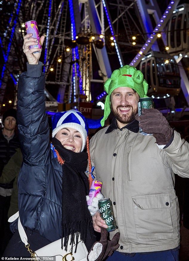 Partygoers in Edinburgh gear up to celebrate Hogmanay 2026, smiling with cans of beer in their hands