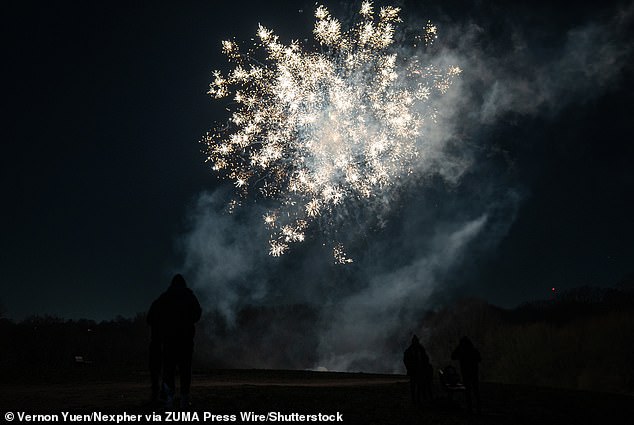 Fireworks fill the sky on Parliament Hill as onlookers watch on during New Year's Eve celebrations