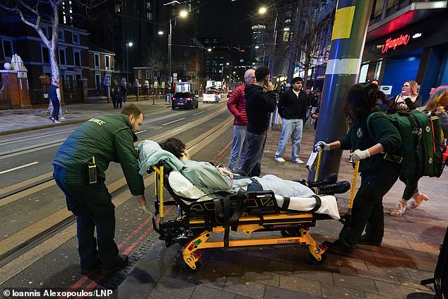 A reveller is taken away on a stretcher by paramedics while out on New Year's Eve in Birmingham city centre