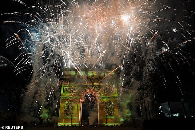 Fireworks explode as the word 'Paris' is projected onto the Arc de Triomphe during the New Year's celebrations in France