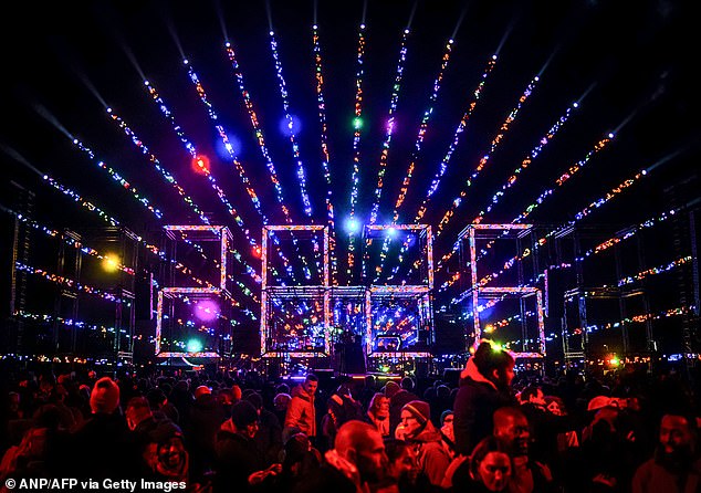 Revellers watch a fireworks and light show for children in Amserdam on December 31, 2025