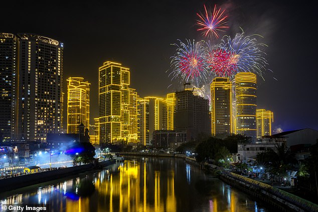 Fireworks explode over skyscrapers on New Year's in Manila, Philippines