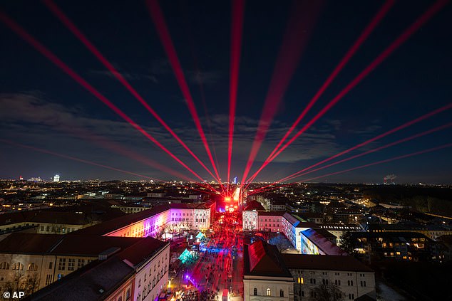 Visitors watch a laser show for New Year's Eve in Munich, Germany tonight