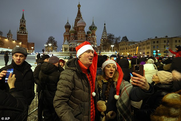 People celebrate the New Year outside Red Square near the Spasskaya Tower and the St. Basil's Cathedral in Moscow