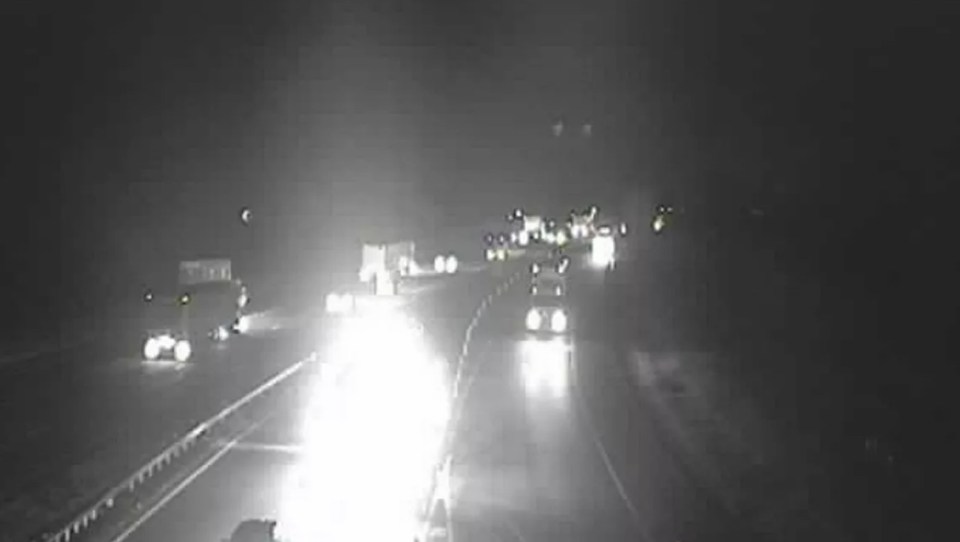 Nighttime highway traffic with bright headlights and taillights.