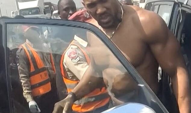Anthony Joshua being moved from a Lexus after a car crash in Nigeria. He escaped death on Nigeria's deadliest road where 73 people have died in just three months