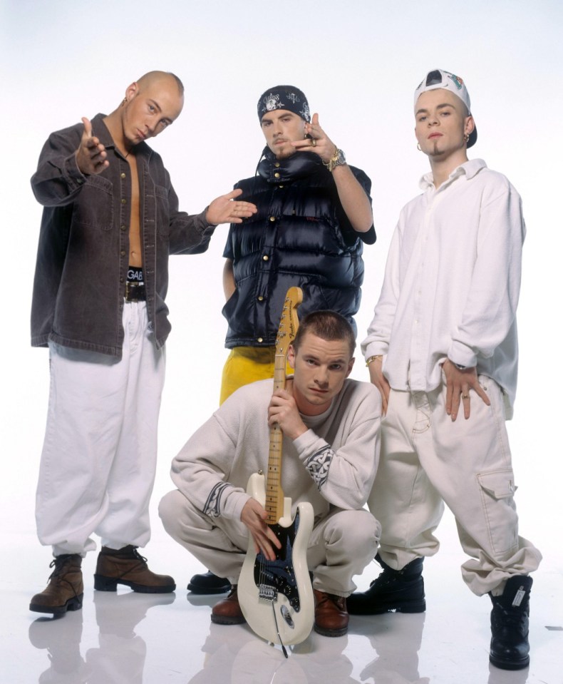 East 17, an English pop boy band, poses with an electric guitar.