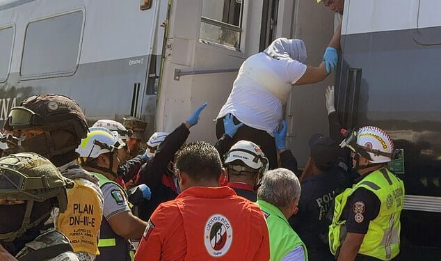A passenger is helped off of the train, which partially derailed on a journey in Mexico on Sunday