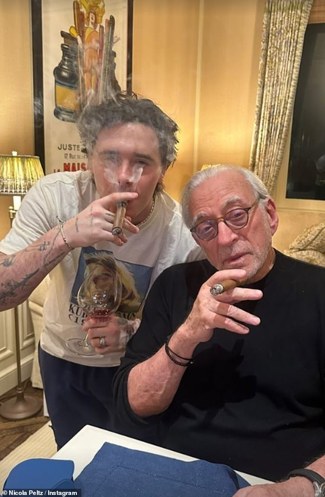 Brooklyn is pictured enjoying a cigar with his billionaire father-in-law while celebrating Hanukkah in 2023. Nelson is worth an estimated £1.3 billion ($1.6billion)