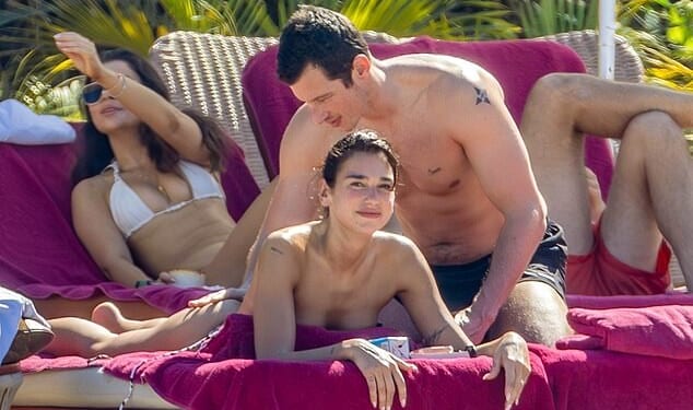 Bikini-clad Dua Lipa had sun lotion rubbed into her bottom by her doting husband-to-be Callum Turner as they hit the beach in Mexico on a luxury trip on Monday