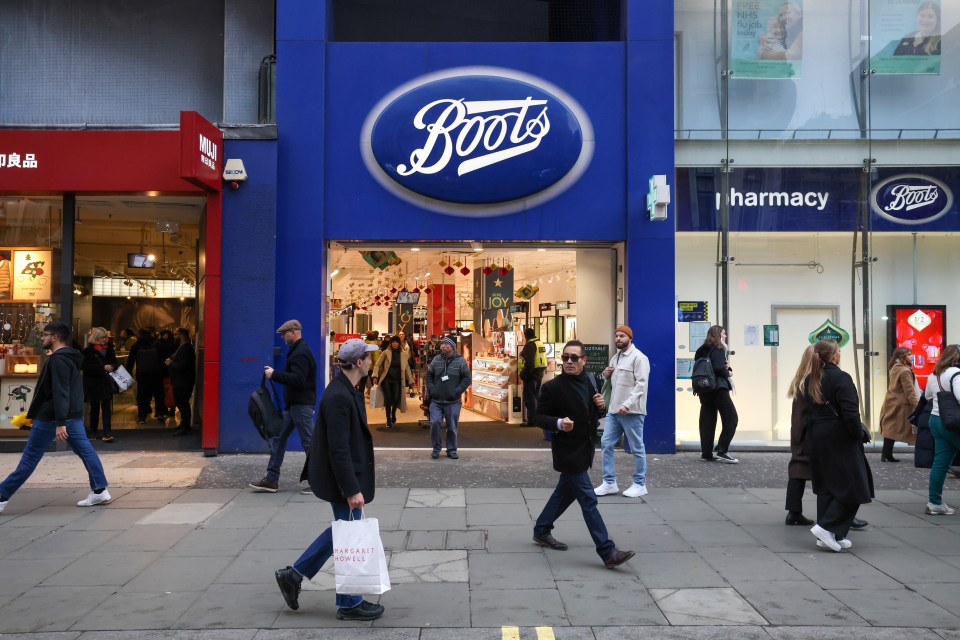 Pedestrians walking past a Boots store in London.