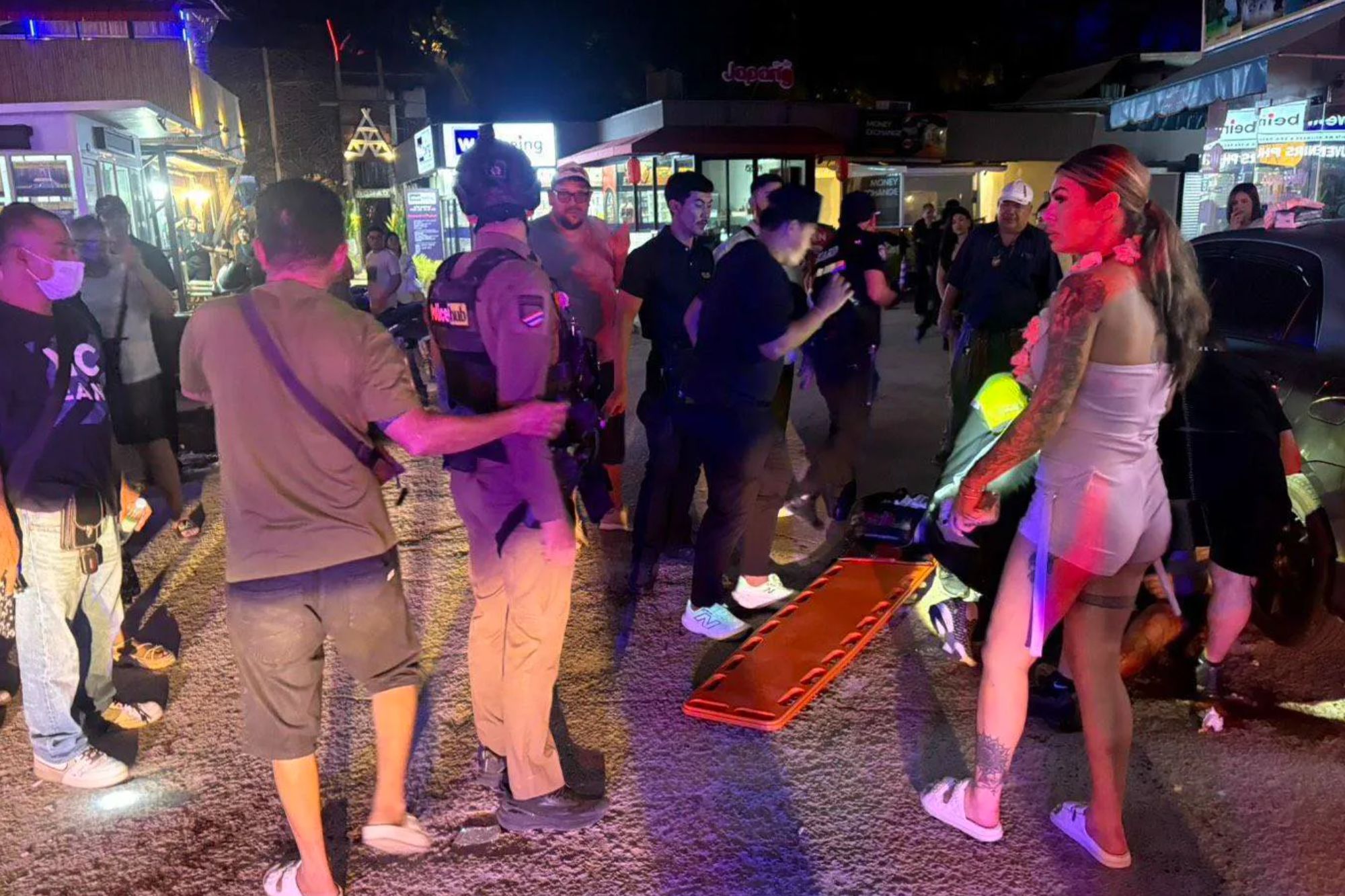 An image collage containing 1 images, Image 1 shows Paramedics and police attend to a victim on a street at night