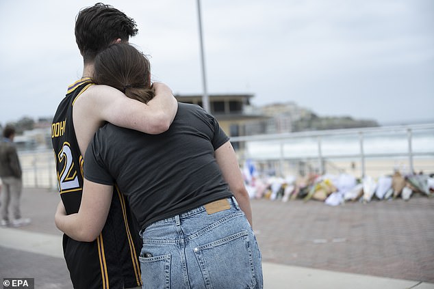 Mourners gather near floral tributes left to the victims of the Bondi Beach massacre