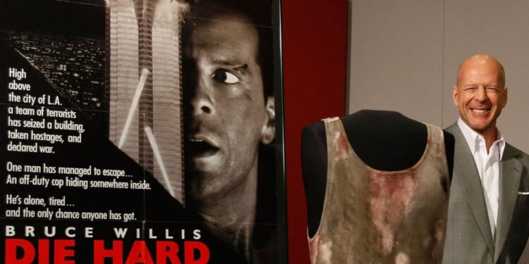 Actor Bruce Willis poses with objects from the "Die Hard" series of films that he donates to the Smithsonian's National Museum of American History June 27, 2007 in Washington, DC.