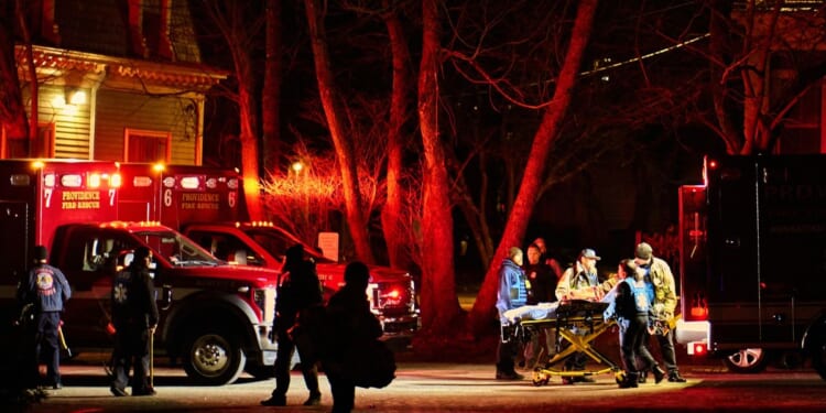 First responders with the Providence Fire Department maneuver an empty stretcher near the Barus and Holley building, home to the engineering and physics departments and the site of a mass shooting, at Brown University campus in Providence, Rhode Island, on Dec. 13, 2025.