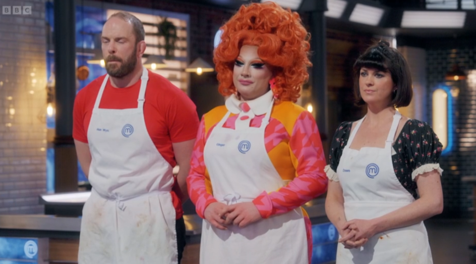 Three contestants, one man and two women, wearing white aprons with the MasterChef logo.