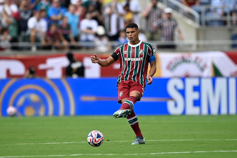 Thiago Silva in a red and green striped jersey on a football pitch.